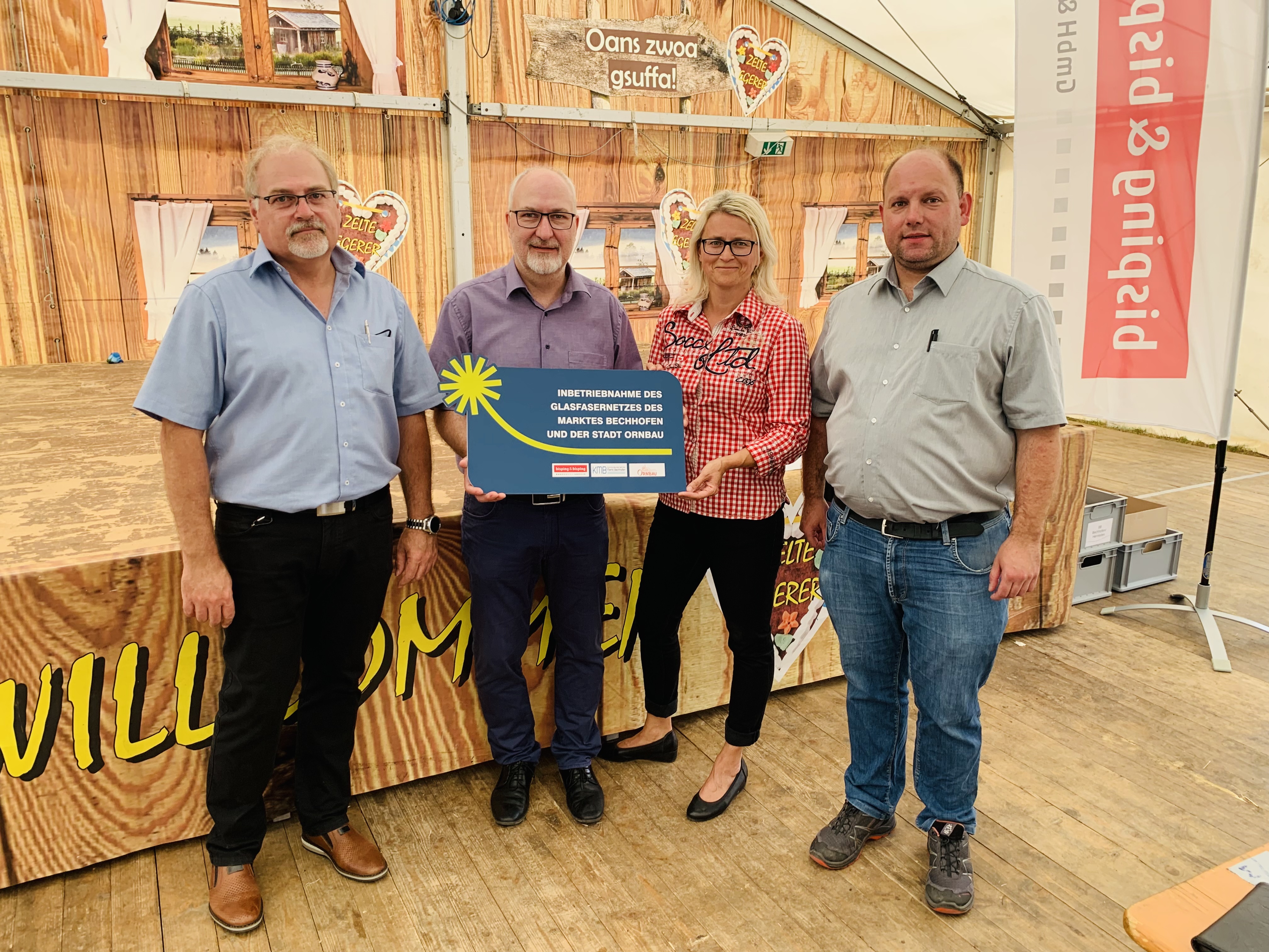 Feierliche Fertigstellung des Glasfasernetzes in Bechhofen am 23. Juli 2022: Bürgermeister Helmut Schnotz, Breitbandpate Bernd Kober und Susi Bisping (Bisping & Bisping) stoßen im Kirchweihzelt mit Bürgerinnen und Bürgern auf die erfolgreiche Inbetriebnahme des Highspeed-Internets an.
